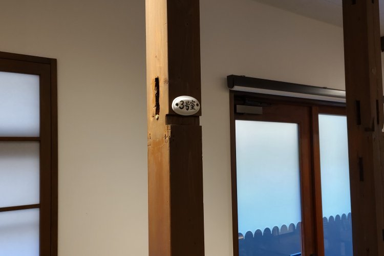 店内の柱にあえて付けたままにしてある部屋番号の札。ここがアパートだった頃の名残だ。