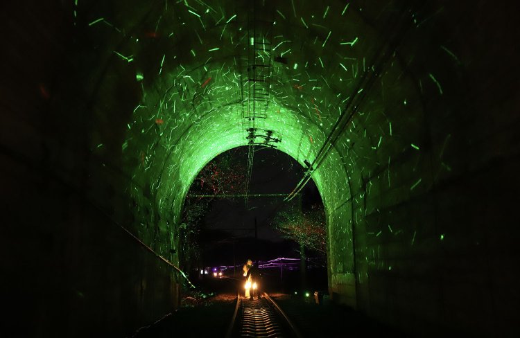 信越本線新線の一部を利用した廃線ナイトウォーク。下り1号トンネルを抜ける頃、緑色の光の粒子が内部を彩る（撮影＝鈴木健太）。