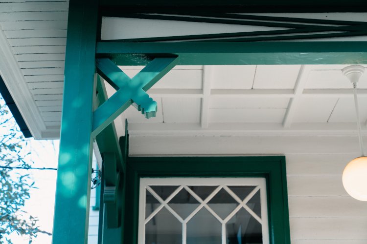 玄関ポーチの方杖（斜めに補強されている棒部分）や、窓の装飾にも特徴的なデザインが見られる。