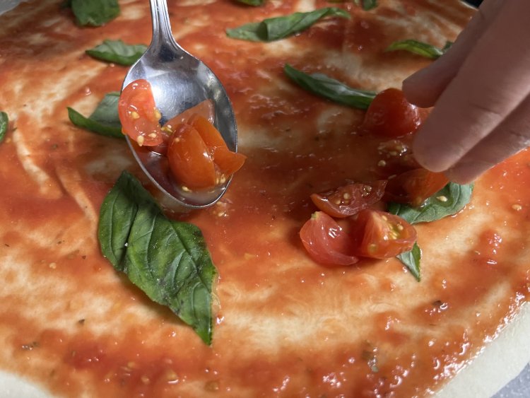 さらにバジル、チェリートマトをのせていく。水牛モッツァレラとエキストラバージンオリーブオイルをかけて完成。