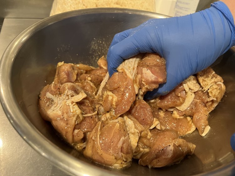 鶏もも肉を手でよく揉み込み、調味料をしっかり染み込ませる。それにしてもひと切れが大きい！