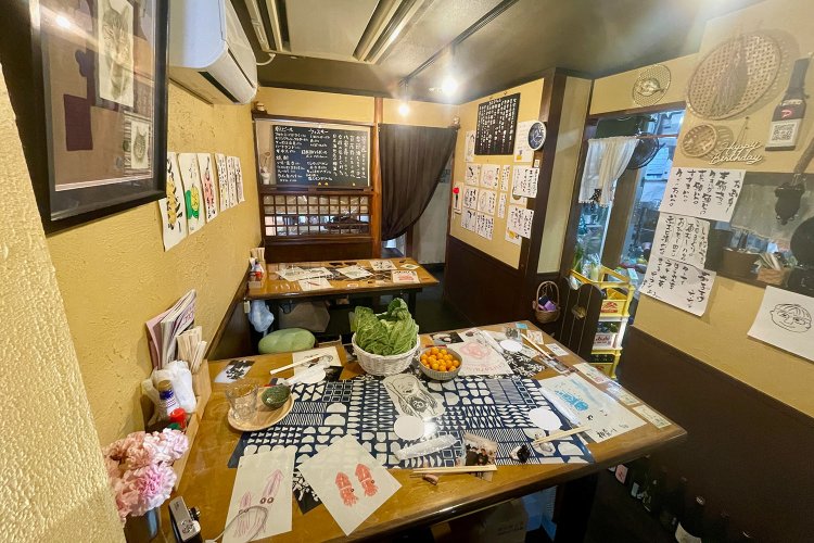 高さの違う机が2台、立ってよし座ってよし。写真右手に、冷蔵庫や小さな厨房があります。