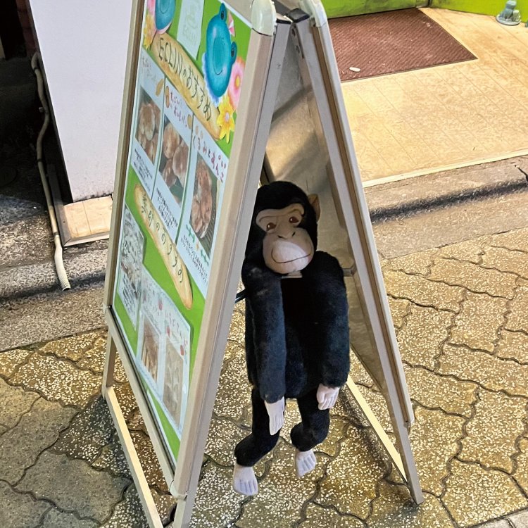 看板の間からちらり。猿のぬいぐるみ。