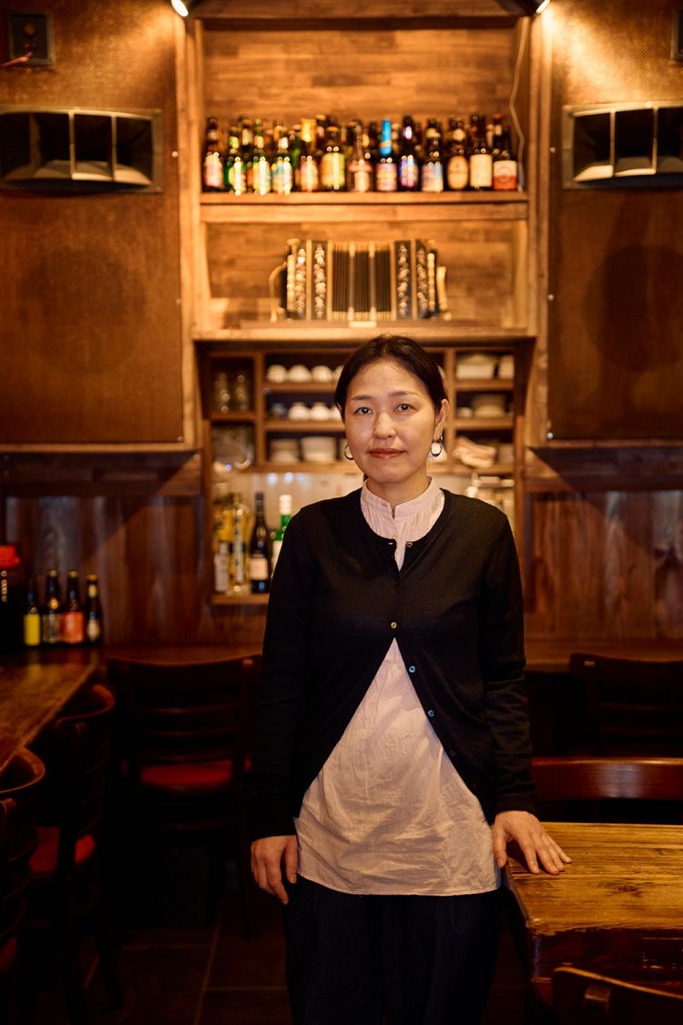 旧店舗から持ってきた大きなスピーカーとバンドネオンをバックに、店長の浅見加代子さん。