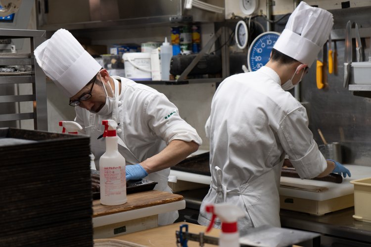 製造スタッフの飯塚有克（いいづかともかつ）さん（左）と髙﨑翔真（たかさきしょうま）さん（右）は焼き菓子の準備中。