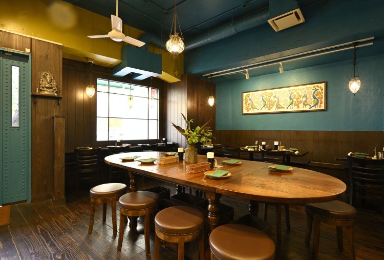 部屋ごとに壁の色が異なるコルカタの住宅をイメージした店内。インド先住民族の描いたゴンド画が映える。