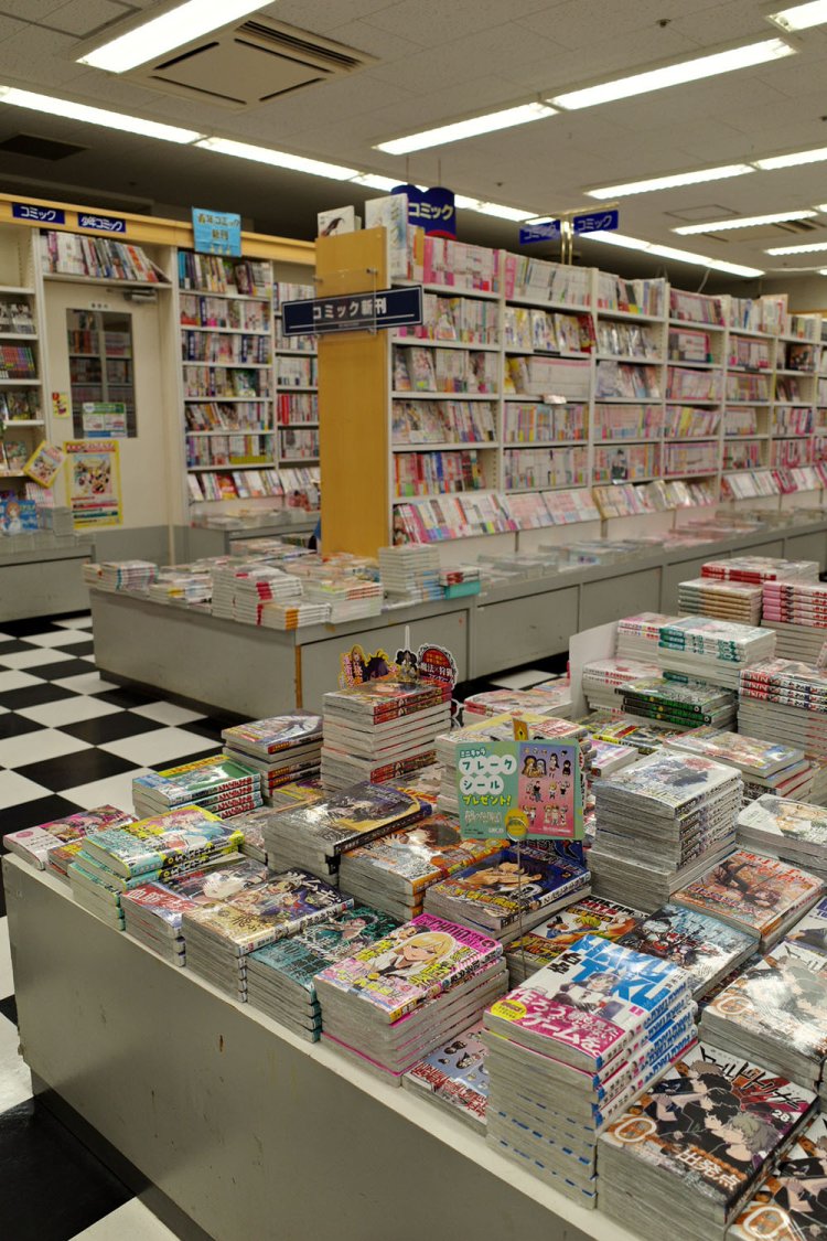 コミック売場。新刊が並ぶ平台と既刊の棚。