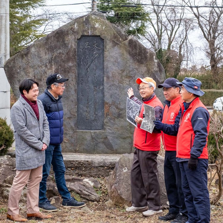 海軍航空殉職者慰霊塔の前に立つ安部次男会長（中央）ら阿見観光ガイドの皆さん。春と秋にはウォーキングイベントも開催。