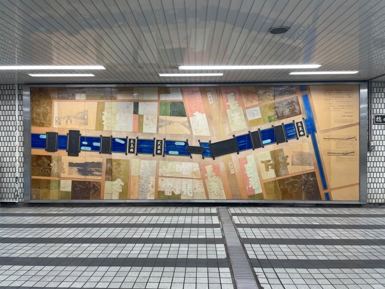 連絡通路内モニュメント。明るく表示された橋名板はレプリカらしい。