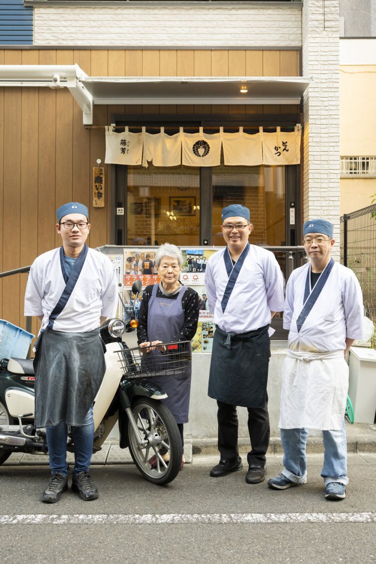 配達バイクと共に猛さん親子（中央）とスタッフ。