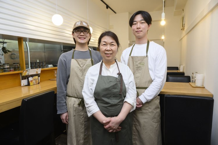 息子の信孝さん（右）は不定期ながらも本間さんを手伝う。店内のお花は近藤薫さんが担当。