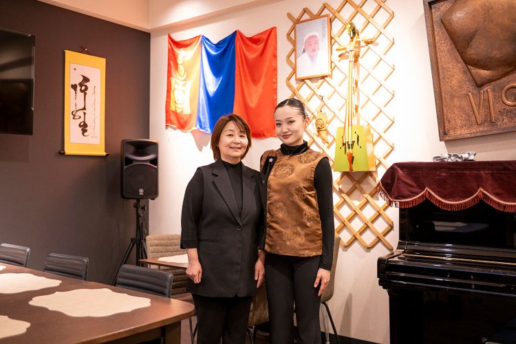 店を切り盛りするウルトナサンさん（左）と民族衣装姿の留学生スタッフ。