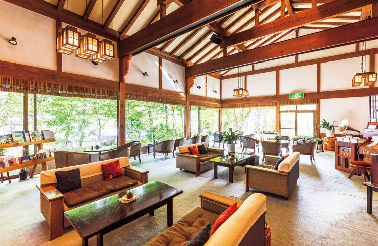 開放感のあるロビーから庭を眺める。天井を見上げると9mもある立派な米マツの梁が4本並び、格調高い雰囲気が漂う。