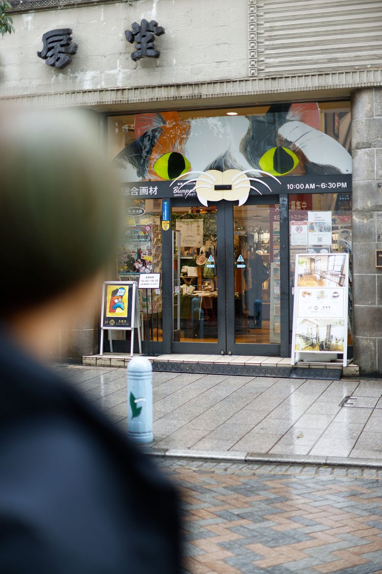 『三省堂書店』向かいの『文房堂』は明治20年（1887）創業の画材店。入り口の猫に釘付け。