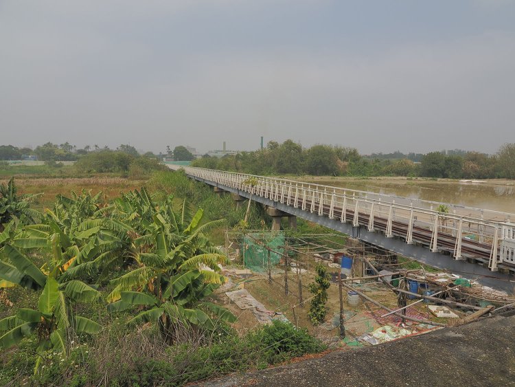 虎尾橋梁の全景を南側から見る。上路プレートガーダ―が続く。奥に虎尾糖廠の煙突が見える。