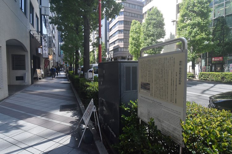 人形町通りの歩道にひっそりと立つ芝居町跡の解説板。