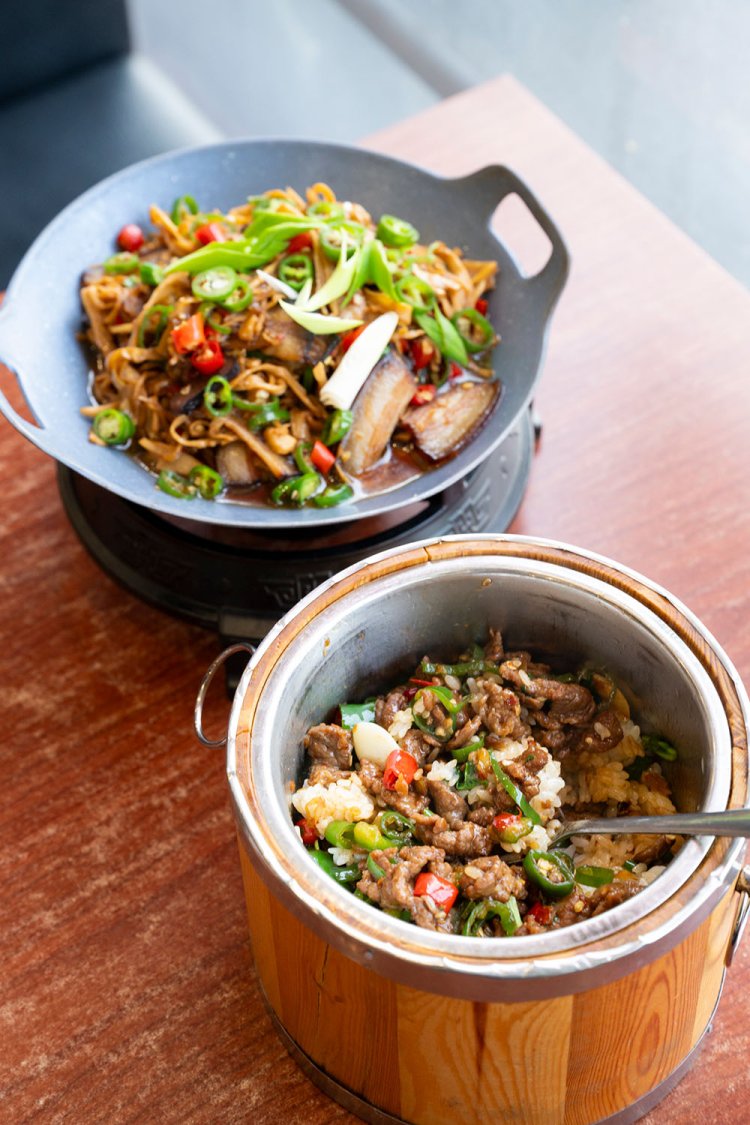 筍と腊肉（ラーロウ＝燻製豚肉）炒め1880円（奥）、ランチの牛肉の湖南風炒め木桶ご飯1180円。