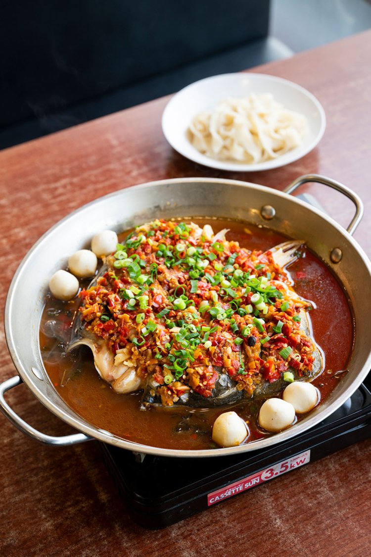 胖头鱼（パントウユイ）という魚を4種の発酵唐辛子で煮込んだ剁椒魚頭（ドゥオジャオユイトウ）2980円。シメは麺を汁につけて。