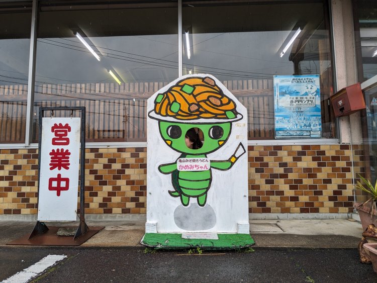 旅先で出合った「ラッキー顔ハメ」。手描きの味わいが愛おしい。「かめみちゃん」の表側。