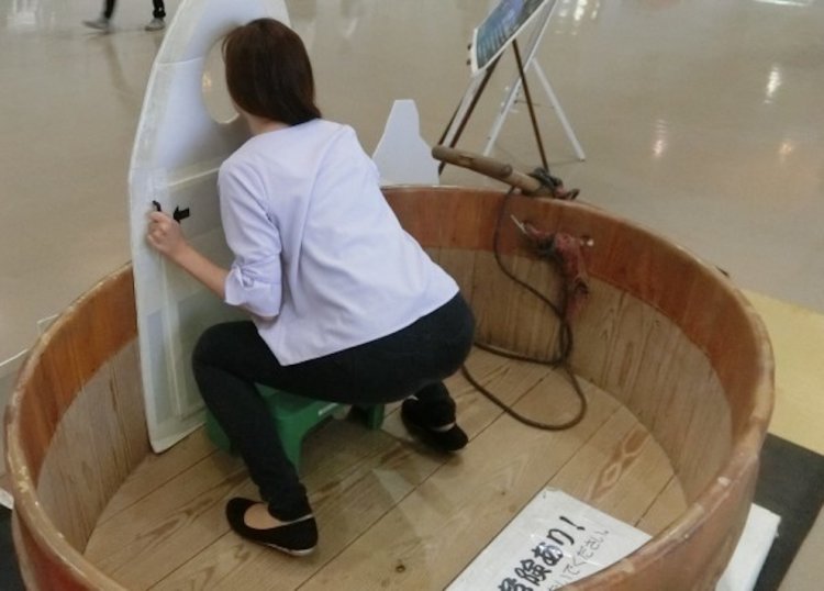 佐渡のたらい舟に乗る海女になれる看板。台や持ち手、注意書きなどに細やかな気配り。