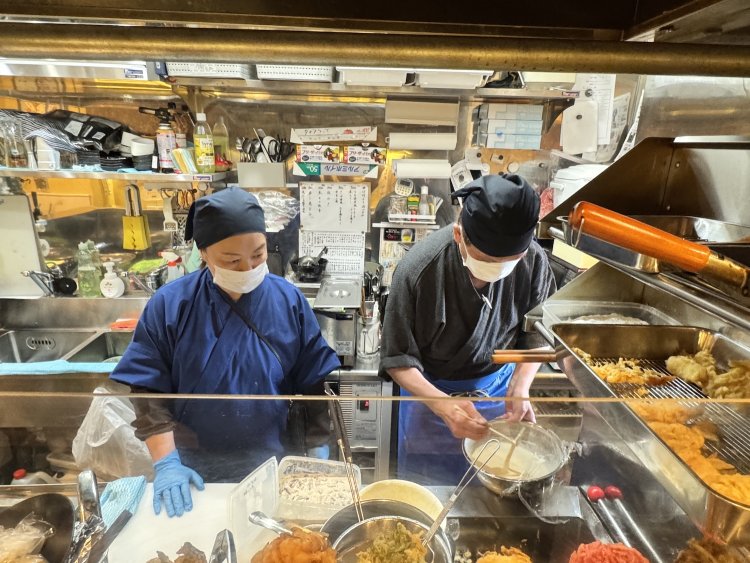 働きながら従業員にいろいろ教えている坂野さん。