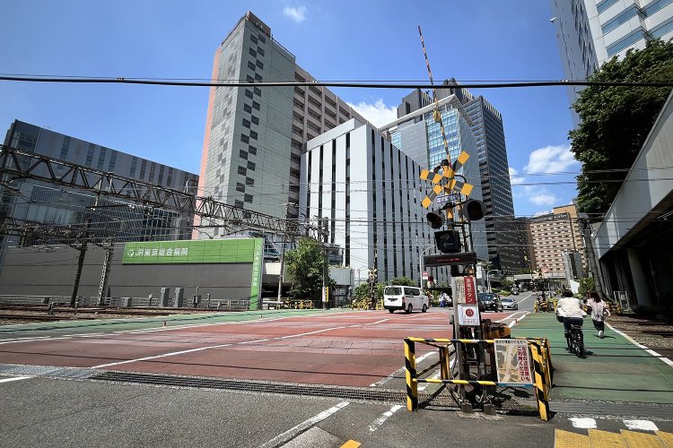 南から見たところ。踏切の北西側にはJR東京総合病院がある。
