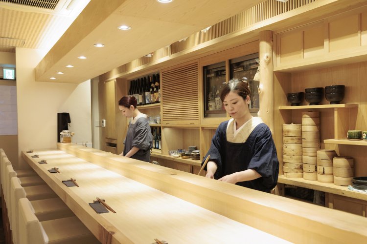 杉玉が目印の『旬蕾』。凛としたカウンター席で、女将の中村照葉さん（手前）、松岡萌さんがもてなす。