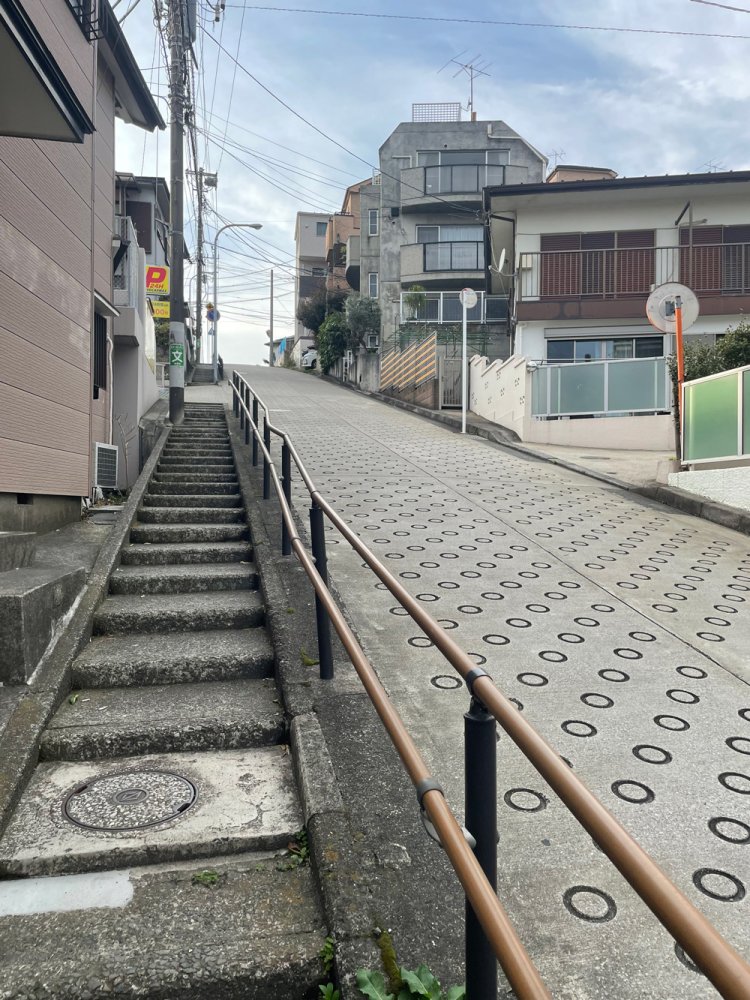坂の脇に階段があるくらいキツい角度。