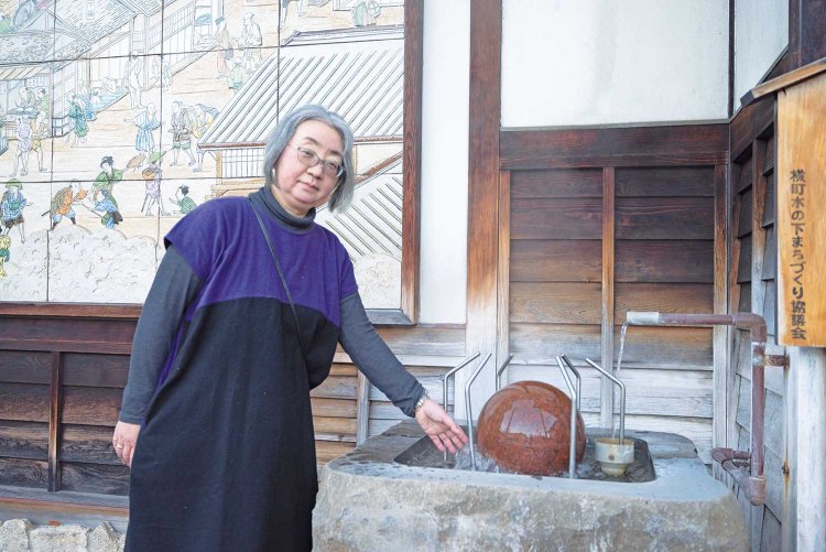 「朝御饌祭」ツアーで下諏訪最古の源泉・綿の湯を案内する智子さん。