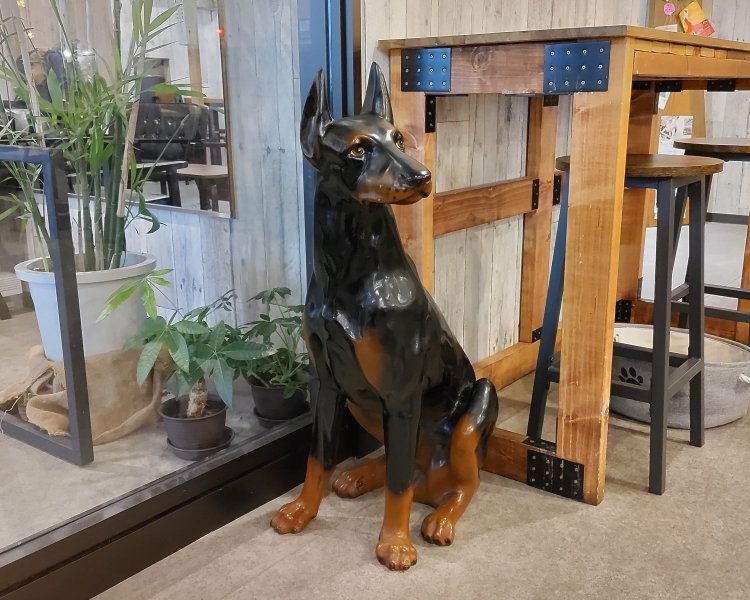 オーナーが愛するドーベルマンの置物。ガラス扉で区切られた奥のフロアはペット同伴OKだ。