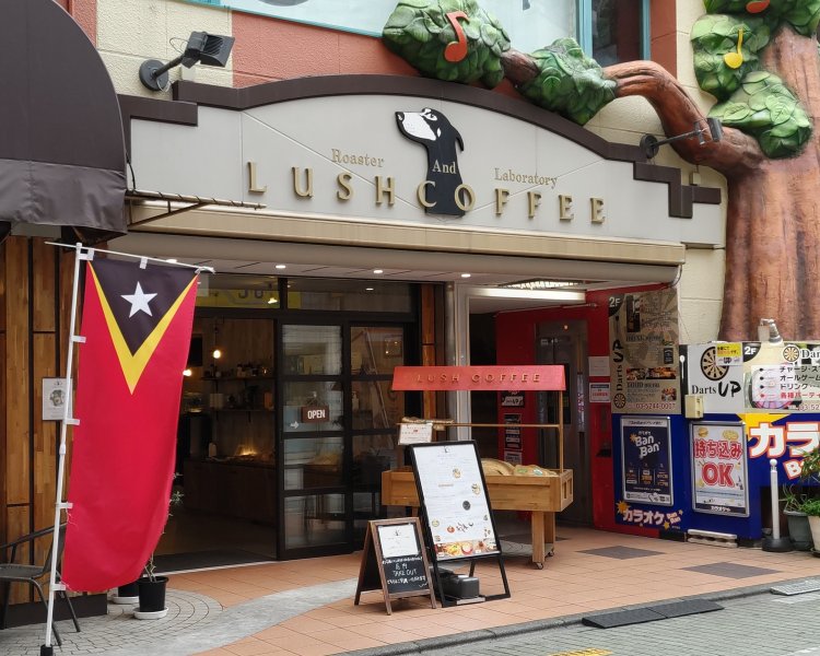 ドーベルマンが描かれた店名のロゴや、東ティモールの国旗をあしらったのぼりが目印。