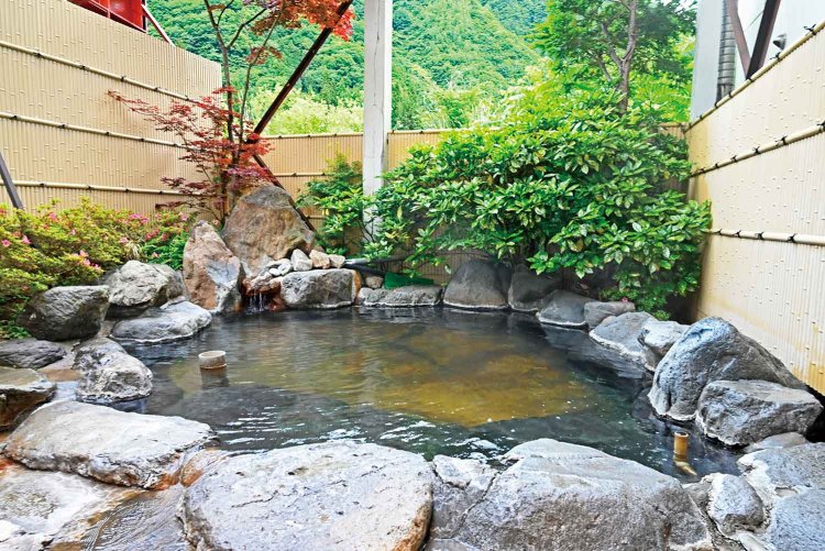 湯の花が舞う源泉かけ流しの露天風呂。