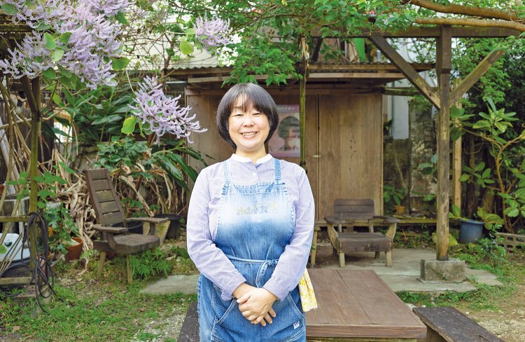 店主の辻佐知子さん。「この場所で沖縄の四季を感じてください」。