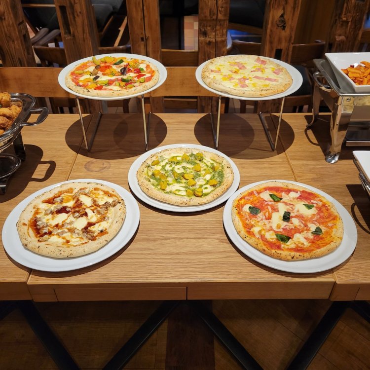 パスタと並ぶ人気メニュー、ピッツアも配膳台に並ぶ。