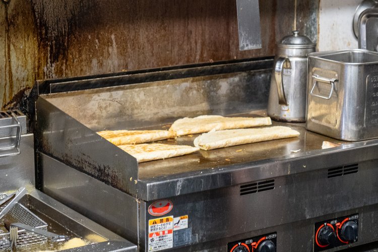 鉄板の上で焼かれているのは、ケサディーヤ。中にチーズが入っている。