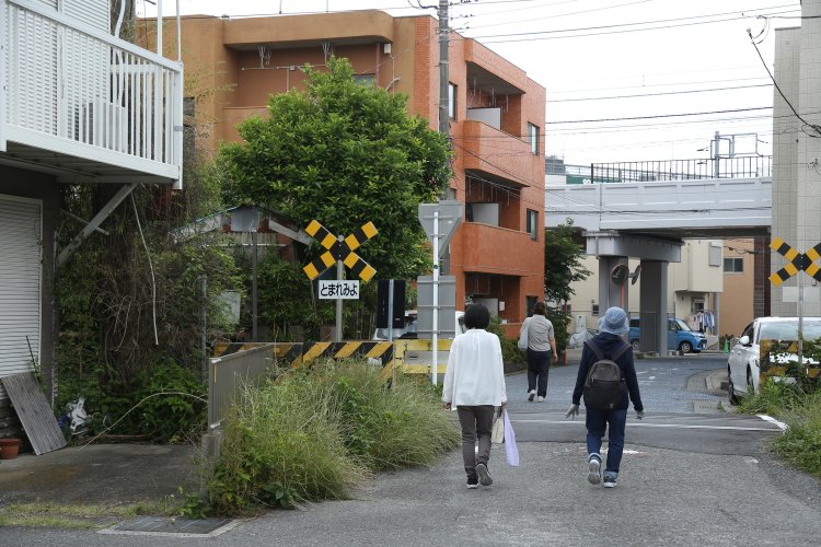 日中は列車がやってこない“どんづまり”の踏切は、住宅街の中にある。