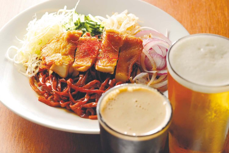 麺類のなかでも人気が高い、台湾の混ぜそばガンバン1050円。揚げ鶏、ネギなどを平打ち麺とタレに絡めていただく。クラフトビールはスモール700円～、 レギュラー1050円～。