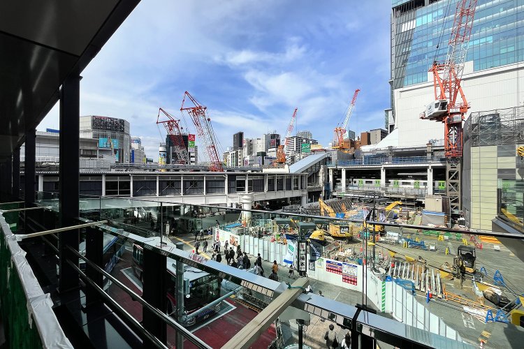 「渋谷フクラス接続デッキ」の中ほどから見る、渋谷駅と「しぶにしデッキ」。