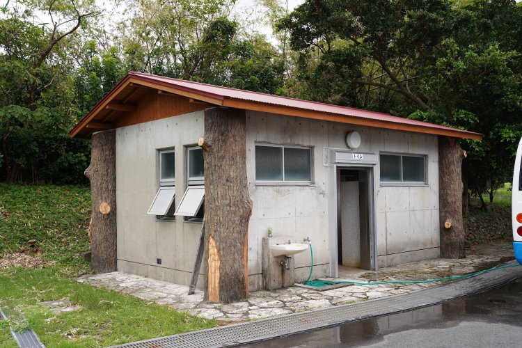 山の中から切り出したようなリアルな擬木が四隅を支える。奄美大島にて。