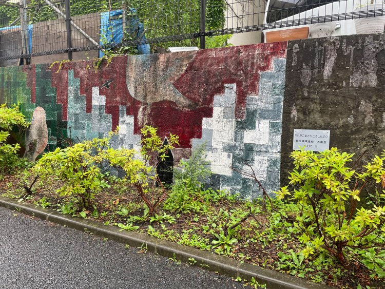 公園の脇の堤防に書かれた絵。都立城東高校美術部の作品は「だれがこまどりころしたの？」という物騒なタイトル。