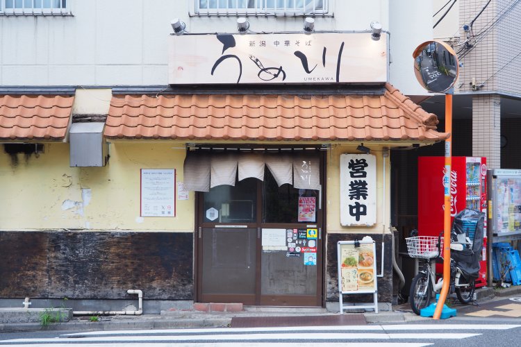 板橋区役所前駅から王子新道を東へ、T字路に面した角地に立つ。