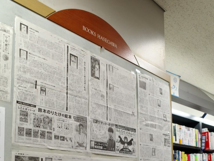 新聞の書評欄を壁に貼り、どの棚にあるか書き込んである。
