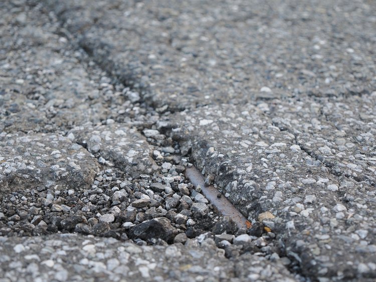 アスファルトから顔を出しているレールの頭部分。