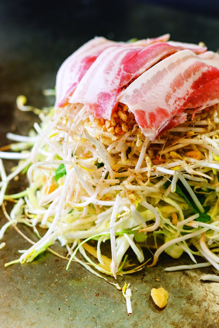 山盛りの野菜を蒸し焼き後、しっかり押さえて焼き、5分の1ほどの厚みに。