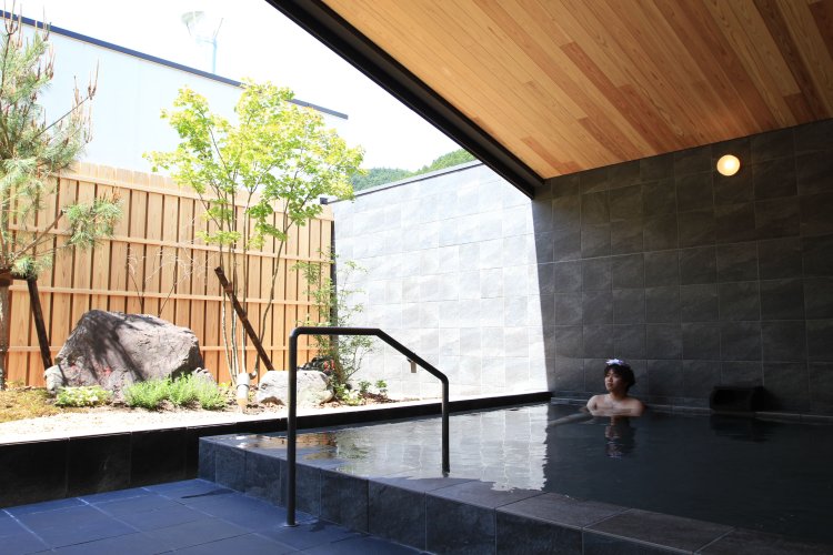 男湯と女湯は左右対称でほぼ同じ造り。地元木材を使う薪ボイラーで湯を加温。