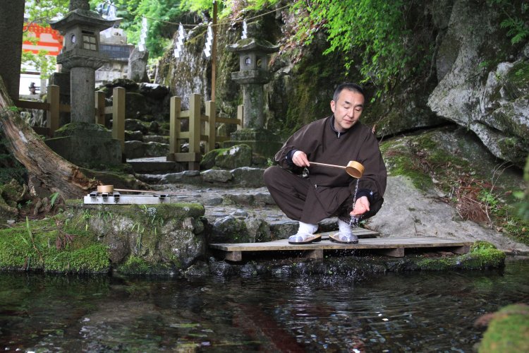 「いまも岩の間から霊水が湧き続けています」と住職の岡田悦雄さん。