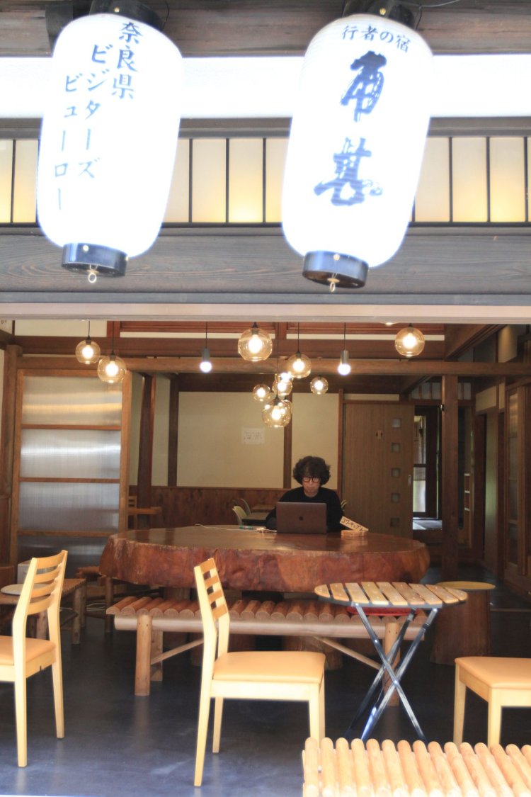 一枚板のテーブルが存在感あり。本来シェアオフィスは2階だが、雰囲気が好きで、1階で作業する人も。