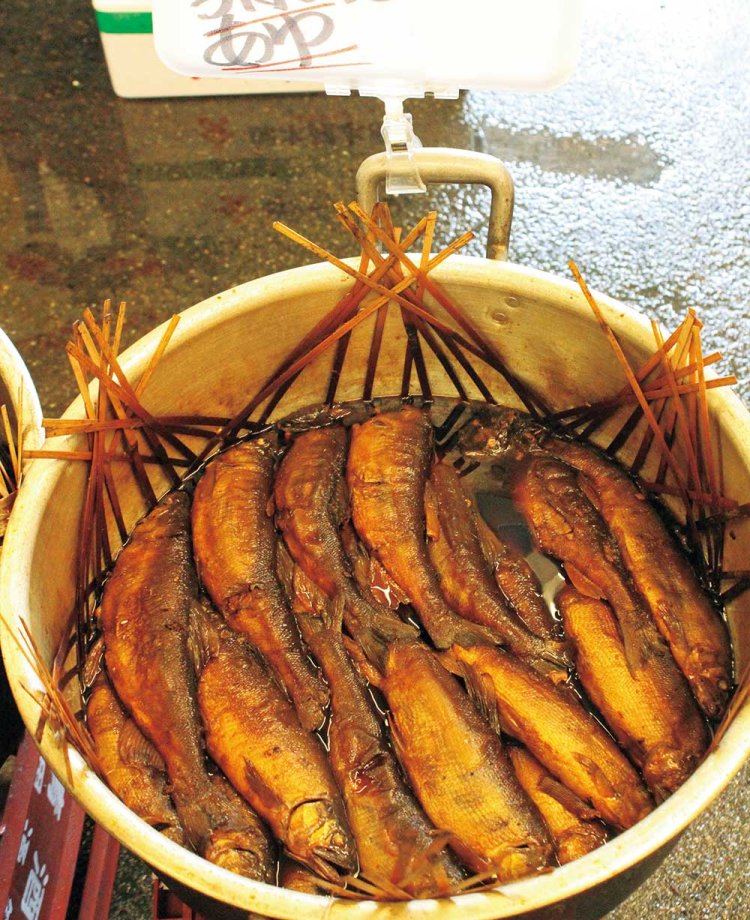 郷土料理「鮎の甘露煮」。大鍋に“縛り煮ザル”で煮崩れないようこっくりと煮つけた鮎は店の名物の一つ。秋はお腹パンパンに卵が詰まった、子持ち鮎の季節。