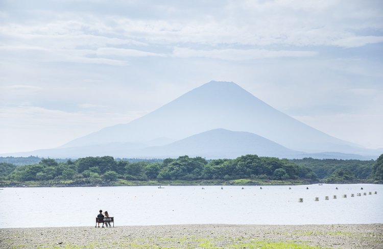 精進湖の他手合浜（たてごうはま）のベンチに座れば、手前の大室山を抱える“子抱き富士”を心ゆくまで眺められる（撮影＝オカダタカオ）。