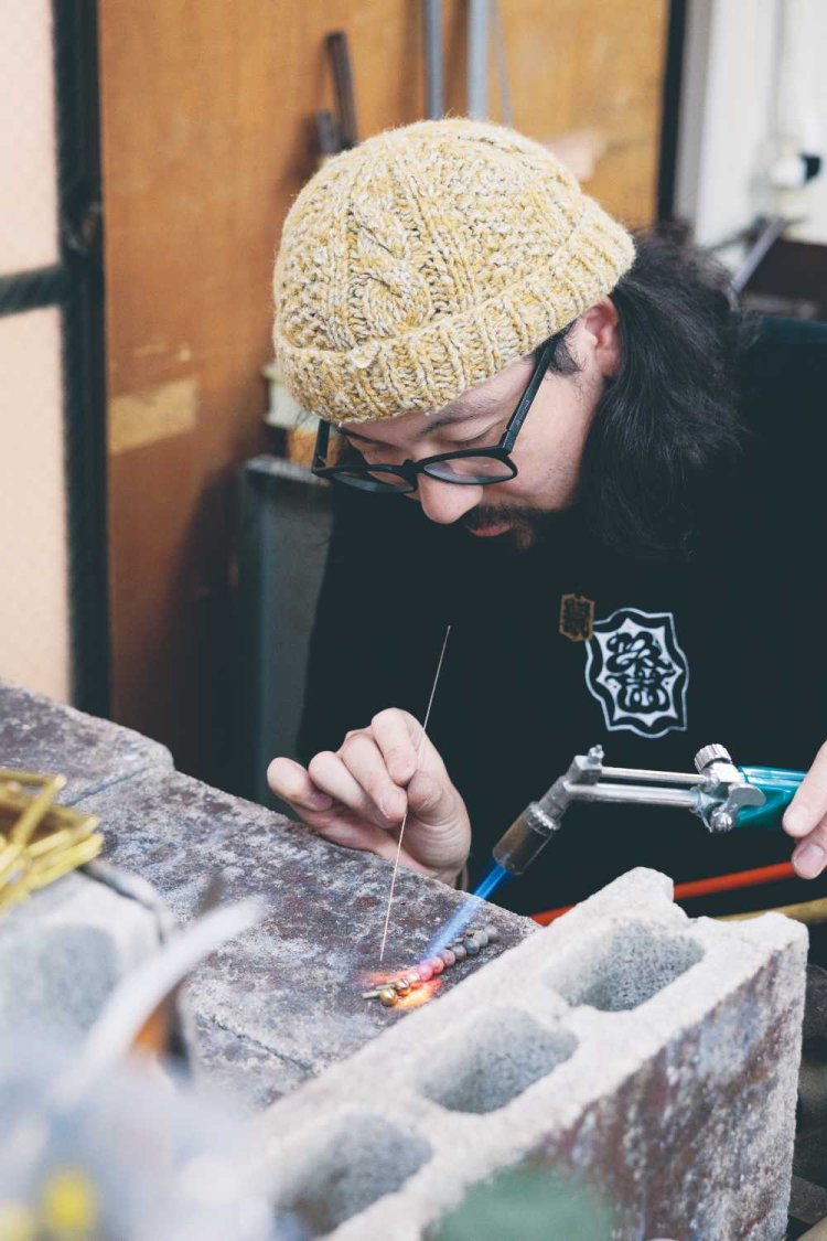 バーナーを使ってパーツを接合する銀ろう付けの作業中の川島悠生さん （通称：ねずみ）。